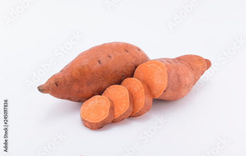Raw sweet potatoes on wooden background closeup white background