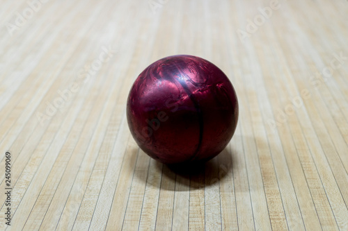 Purple bowling ball on the track in the bowling center