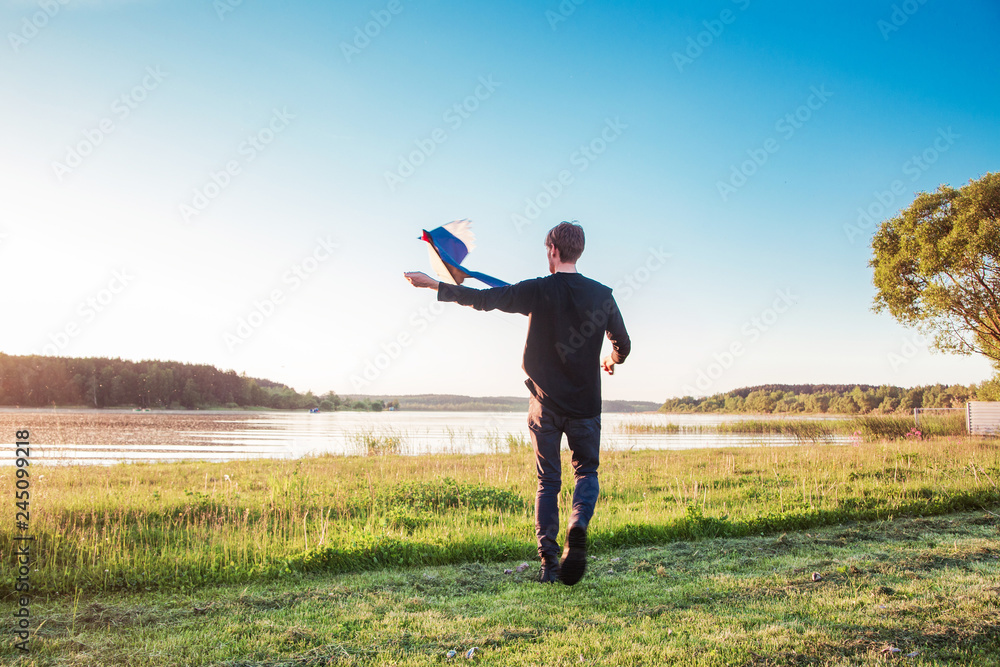 adult guy playing with a kite. Horizontal photo adult guy playing with a kite. Horizontal photo