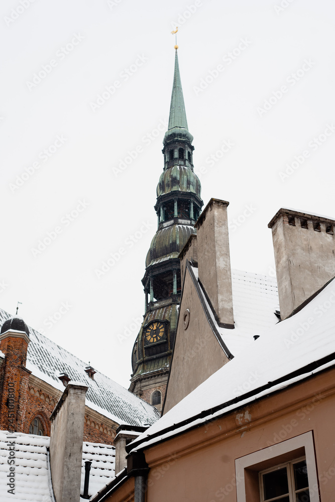 Beatiful tower with clock and snow in winter in Riga 