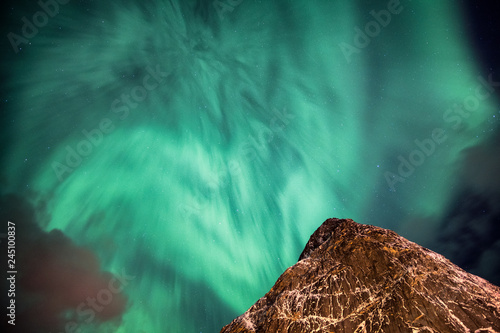 Photos Aurora Borealis (Northern lights) dancing on steep mountain in sky