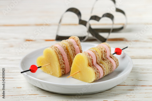 Mini sandwiches parmesan cheese ham bread on skewers in the form of hearts. Valentine's day. Breakfast for loved ones. Selective focus and copy space