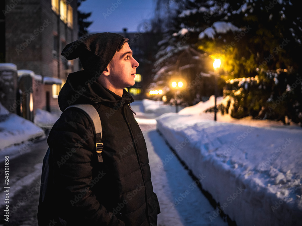 Fototapeta premium attractive man walk in city beetwen nightlights. winter season b