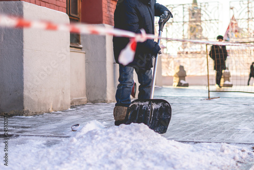 adult man shoveling snow from city streets