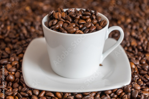 Kaffee Bohnen in und um eine Tasse