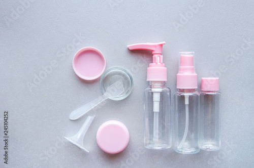 Plastic clear travel bottles for cosmetics soap , gel, lotion, cream, shampoo isolated over grey