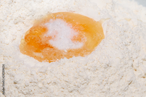 Salt is added to the dough for dumplings in a bowl on the egg