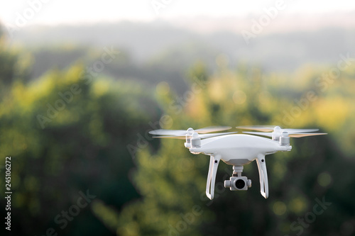 quadcopter drone flying with a camera over a lake.