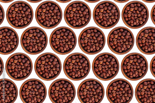 Peeled hazelnut in a wooden cedar plate on a white isolated background. Row of bowls with hazelnut , top view. Peeled hazelnut pattern