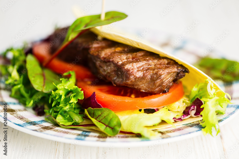 Mexican tortilla stuffed with beef steak and salad and vegetables Mexican tortilla stuffed with beef steak and salad and vegetables