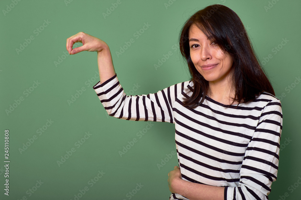 Smiling girl standing against a green wall Smiling girl standing against a green wall