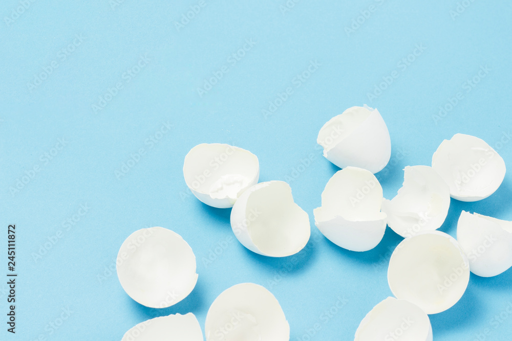White Shell from broken eggs on a blue background. The concept of birth, cooking, replenishment in the family. Flat lay, top view White Shell from broken eggs on a blue background. The concept of birth, cooking, replenishment in the family. Flat lay, top view