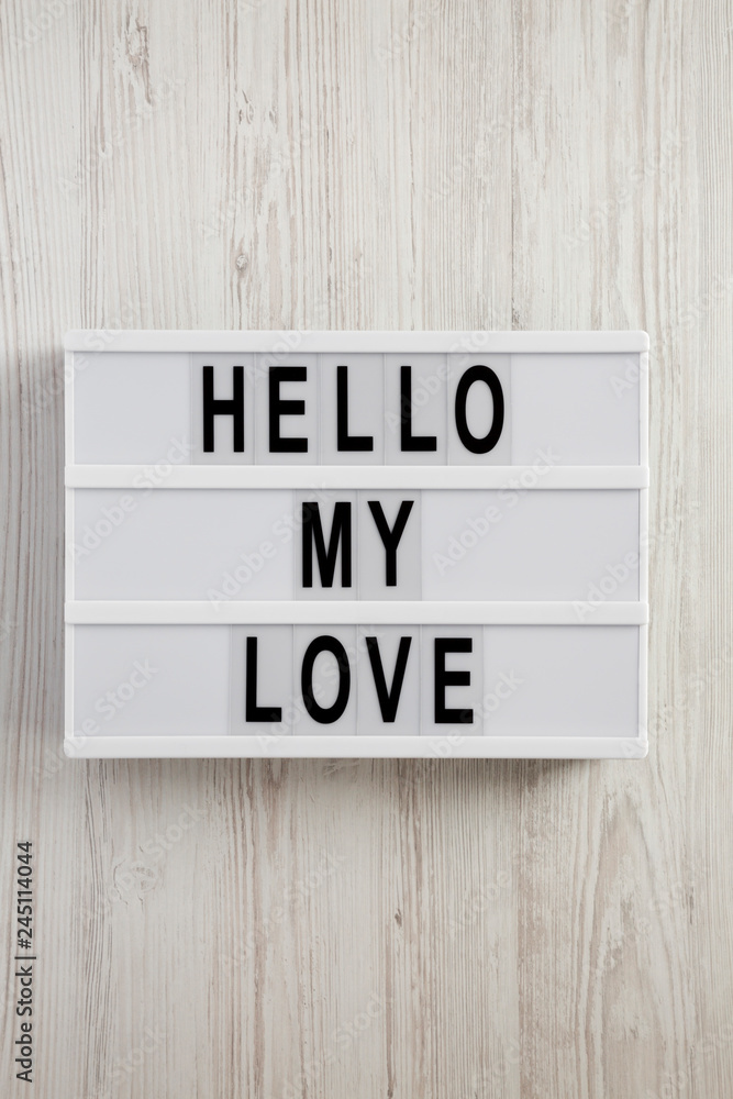 Modern board with text 'Hello my love' on a white wooden background, top view. From above, overhead. Modern board with text 'Hello my love' on a white wooden background, top view. From above, overhead.