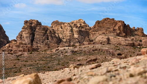 Amazing view of a beautiful canyon in Petra with rocky mountains in distance. Petra is a Unesco World heritage site, historical and archaeological city in southern Jordan.