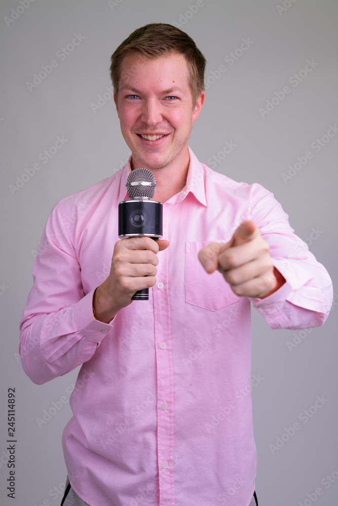 Happy young handsome businessman as host pointing to camera Happy young handsome businessman as host pointing to camera