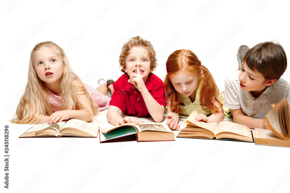 The kids boy and girls laying with books at studio, smiling, laughing, isolated on white. Day of book, education, school, kid, knowledge, childhood, friendship, study and children concept The kids boy and girls laying with books at studio, smiling, laughing, isolated on white. Day of book, education, school, kid, knowledge, childhood, friendship, study and children concept