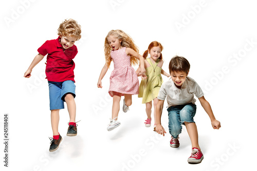 Group of fashion cute preschooler kids friends running together and looking at camera on a white studio background. Day of book, education, school, kid, knowledge, childhood, friendship, study and