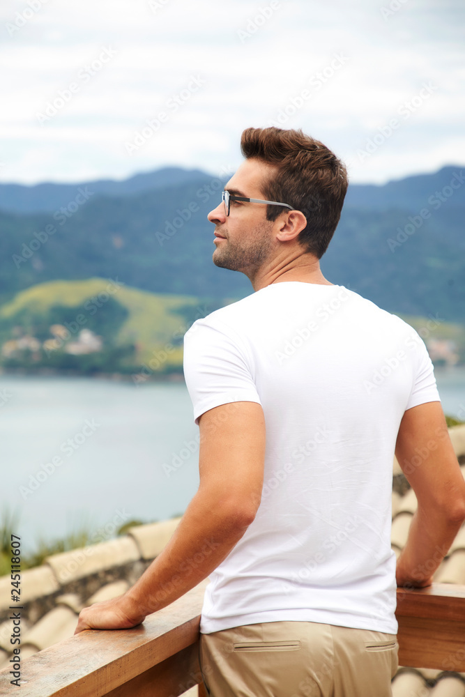Handsome guy in white t-shirt looking at view