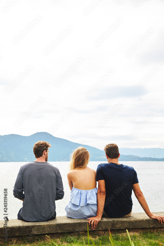 Three friends looking at view from wall