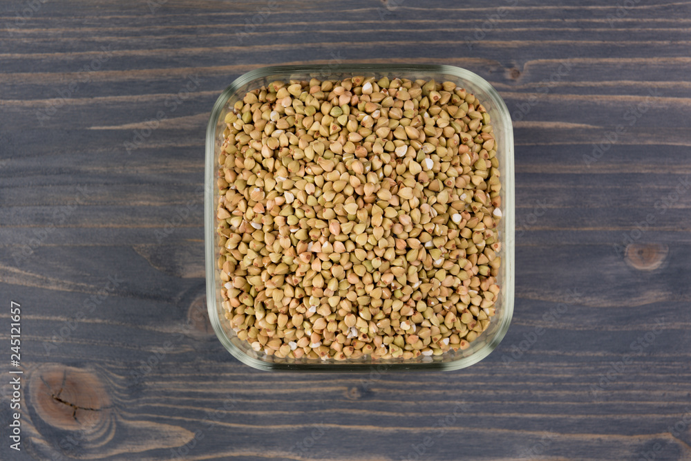 Natural fresh green buckwheat in glass bowl on wooden background. Top view Natural fresh green buckwheat in glass bowl on wooden background. Top view