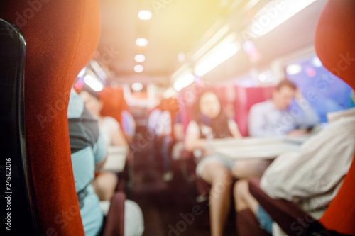 Salon of public transport bus or train with passengers  blurred background