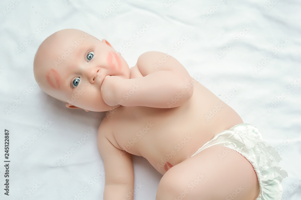 Funny little baby. Infant nappy change and skin care. adorable child with red kisses on the skin Funny little baby. Infant nappy change and skin care. adorable child with red kisses on the skin
