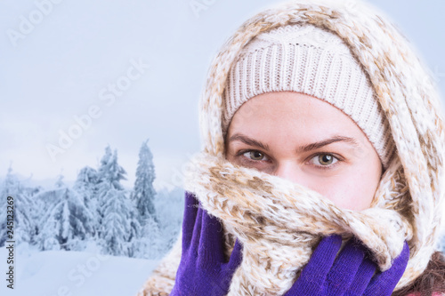 Close-up of woman covering mouth and nose with scarf.