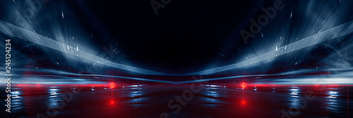 Background wall with neon lines and rays. Background of an empty dark corridor, parking, airport with neon light. Abstract background with lines and glow. Wet asphalt, the reflection of neon lights in