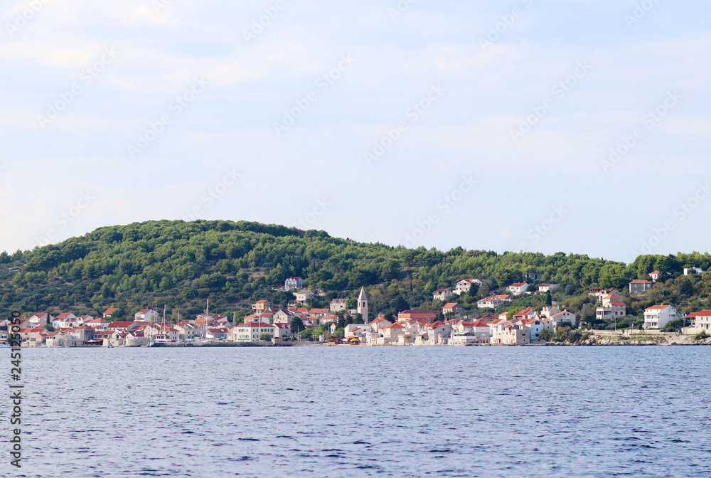 Panorama of a yacht marina in a town in Croatia in the Dalmatia region. The ships moored in the port of a quiet fishing town in a sunny, clear day. Tourist marine business. Murter island