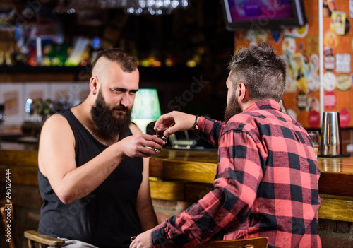 Strong alcohol drinks. Friday relax in pub. Friends relaxing in pub. Drunk conversation. Cheers concept. Hipster brutal bearded man drinking alcohol with friend at bar counter. Men relaxing at pub