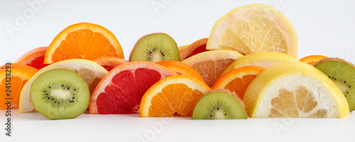 Layers of sliced fruits - kiwi, orange and grapefruits, panoramic crop