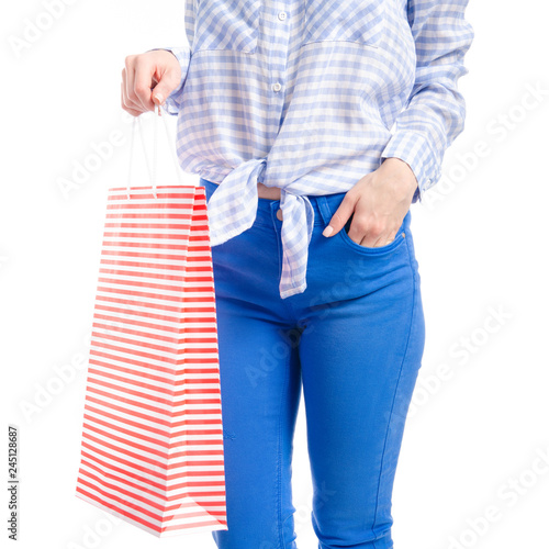 Woman in jeans and blue shirt red bag package in hand fashion buy sale macro on white background isolation