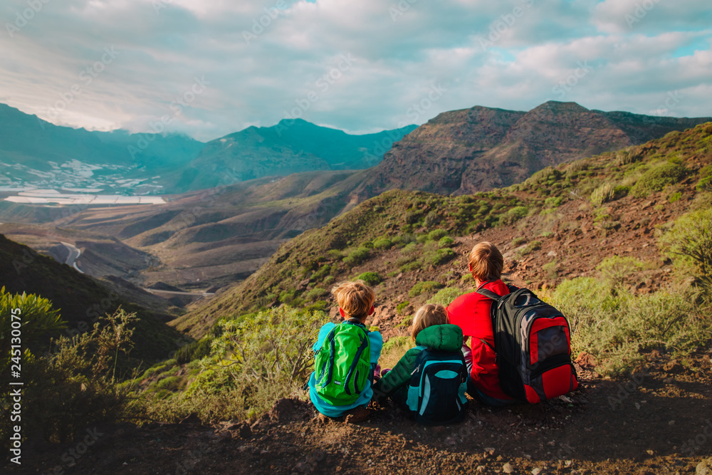 Fototapeta premium father and two kids hiking travel in mountains