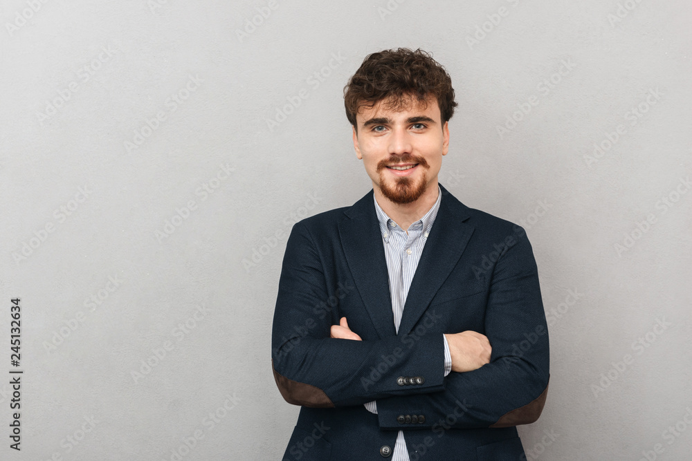 Handsome young business man isolated over grey wall background. Handsome young business man isolated over grey wall background.