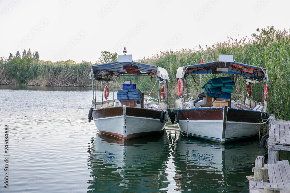 two boats at a pier on a river ferry quayside with rushing still water two boats at a pier on a river ferry quayside with rushing still water