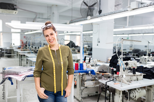 Adult woman designer posing in textile factory.
