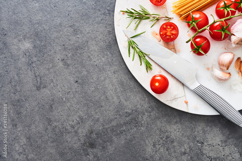 Italian food background. Uncooked integral spaghetti, tomato, rosemary ...