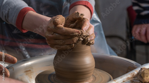 Teaching pottery to children. The teacher gives a master class in modeling