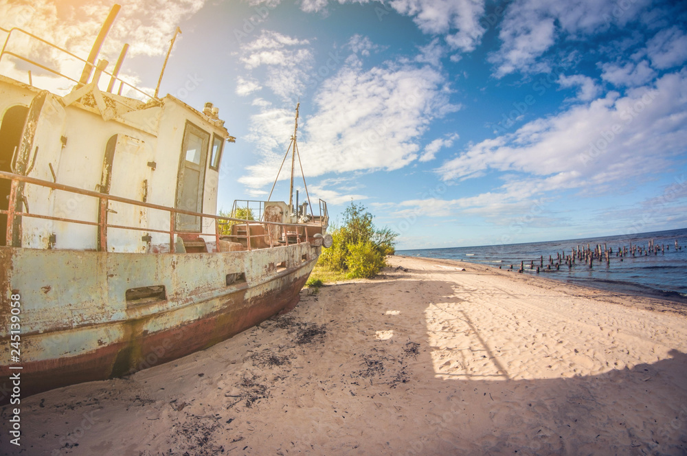 Obraz premium abandoned boat on the sandy shore of a lake on a sunny day. distortion perspective fisheye lens