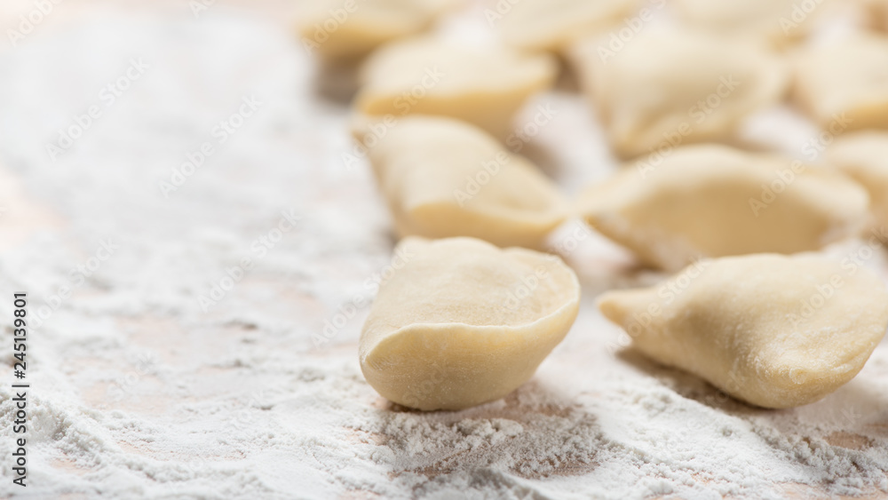 Raw dumplings ready to boil, close up, with copy space. Also known as Vareniks. Ukrainian traditional cuisine