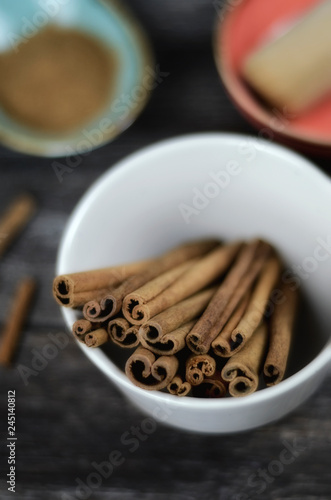 Cinnamon sticks and powder on rustic wooden background