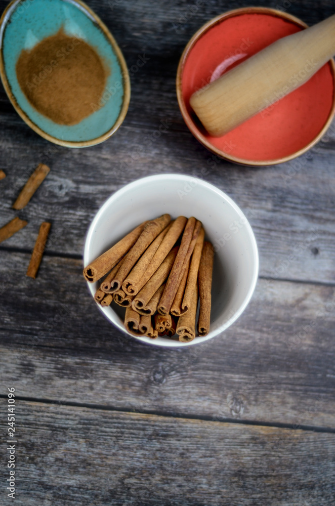 Cinnamon sticks and powder on rustic wooden background