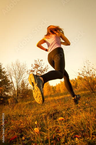 Girl running and jumping at sunset in the park natural environment