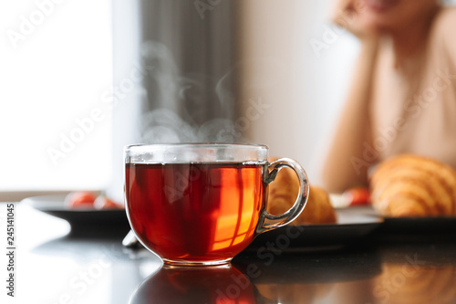 Photography Cropped photo of caucasian woman sitting at table in flat, with hot tea in glass
