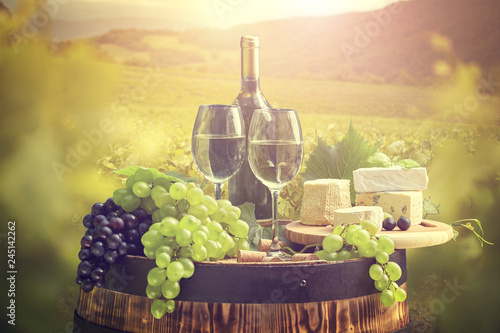 Fototapeta Naklejka Na Ścianę i Meble -  White wine with barrel on vineyard in green Tuscany, Italy