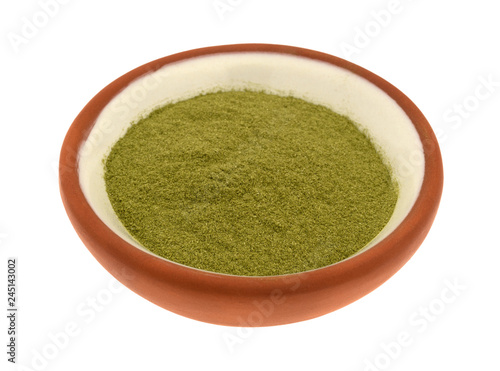 Side view of organic powdered wheat grass in a small bowl