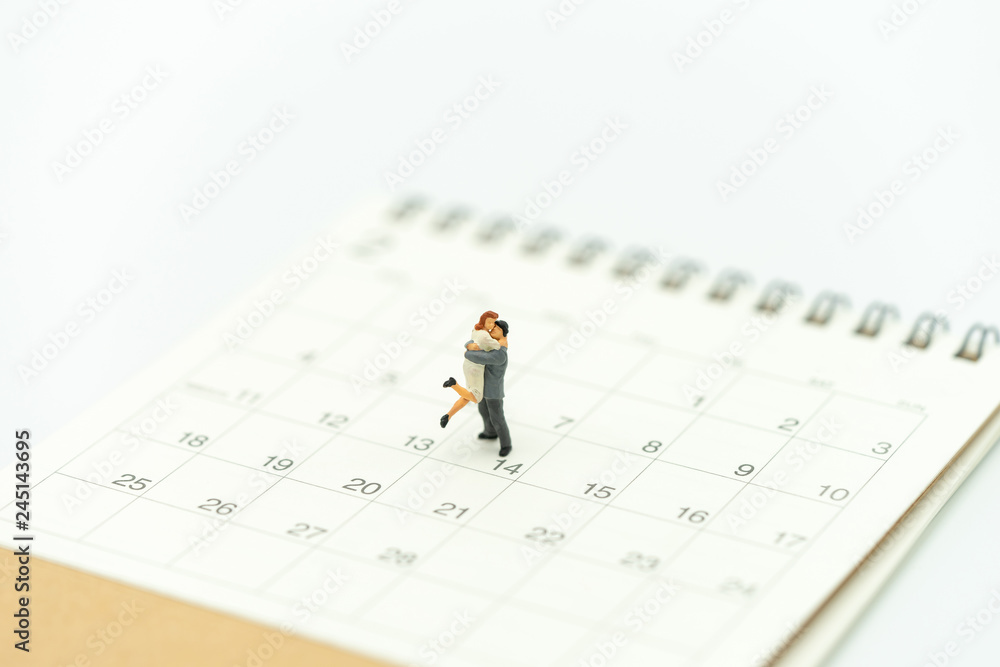 Couple Miniature 2 people standing on Calendar. Day 14 meets Valentine Day. Red heart is the promise of love. using as background Valentine concept with copy spaces for you Couple Miniature 2 people standing on Calendar. Day 14 meets Valentine Day. Red heart is the promise of love. using as background Valentine concept with copy spaces for you