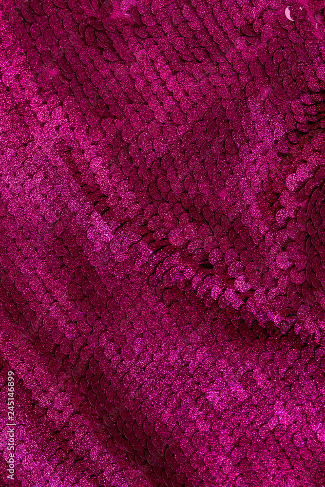 Gloss fuchsia background made of two-sided sequins. Holiday background. Festive concept.