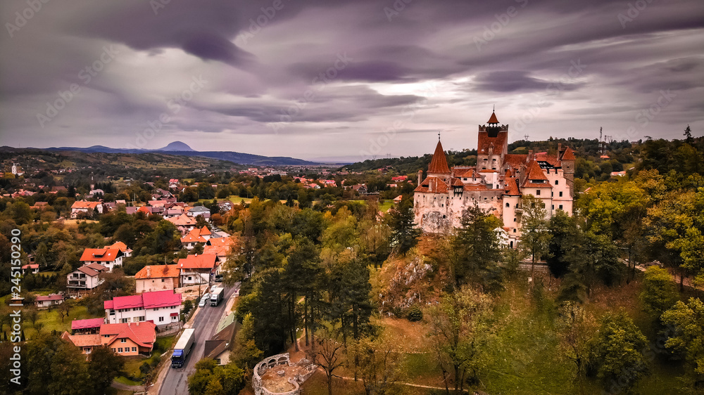 Aerial view of Bran castle in beautiful Transylvania, region of Romania near the Brasov. Cloudy day with dark clouds.