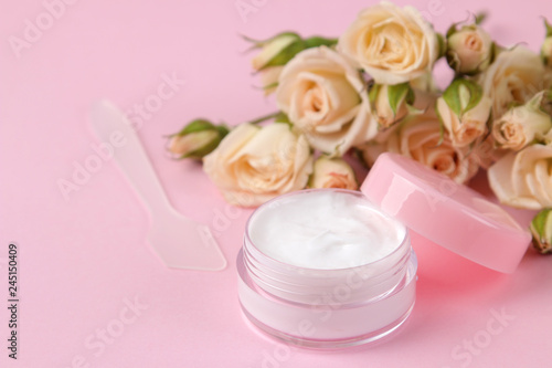 cosmetics for face and body in pink bottles with fresh roses on a delicate pink background. cream and lotion. spa.